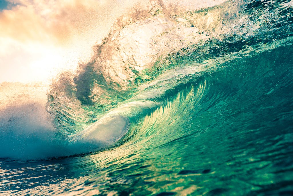 Amazing scenery of azure splashing waves rolling on rippling sea surface beneath light pink sunny sky